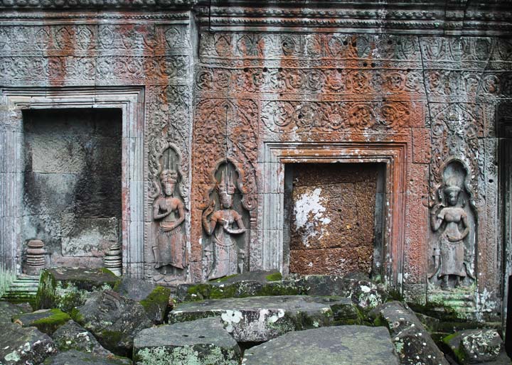 A beautifully detailed bas-relief of an Apsara dancer, gracefully etched into the stone walls of Ta Prohm Temple. Surrounding the figure, intricate Khmer patterns adorn the weathered surface, showcasing the refined artistry of Angkorian craftsmanship. The interplay of light and shadows enhances the delicate curves and textures, highlighting Cambodia’s rich cultural heritage.