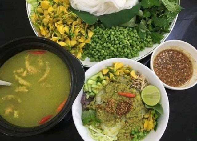 A beloved breakfast dish featuring rice noodles topped with fish-based green curry and herbs, often sold by early-morning vendors. Nom Banh Chok (Khmer Noodles)