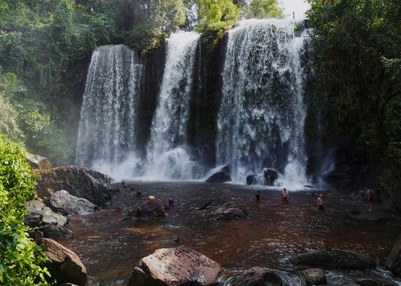 Kulen Waterfall in Phnom Kulen National Park Siem Reap, Cambodia, with people enjoying the water.