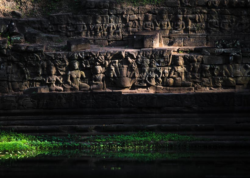 Ancient stone carvings at Steep of Woman Pond near Phimeanakas (Srash Srey or Srash Bros in Khmer) Temple in Angkor Thom, featuring seven heads of Naga and figures of Tevada or Apsara.